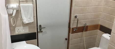 A small bathroom with a white sink, a white toilet, a hairdryer, and a towel rack.