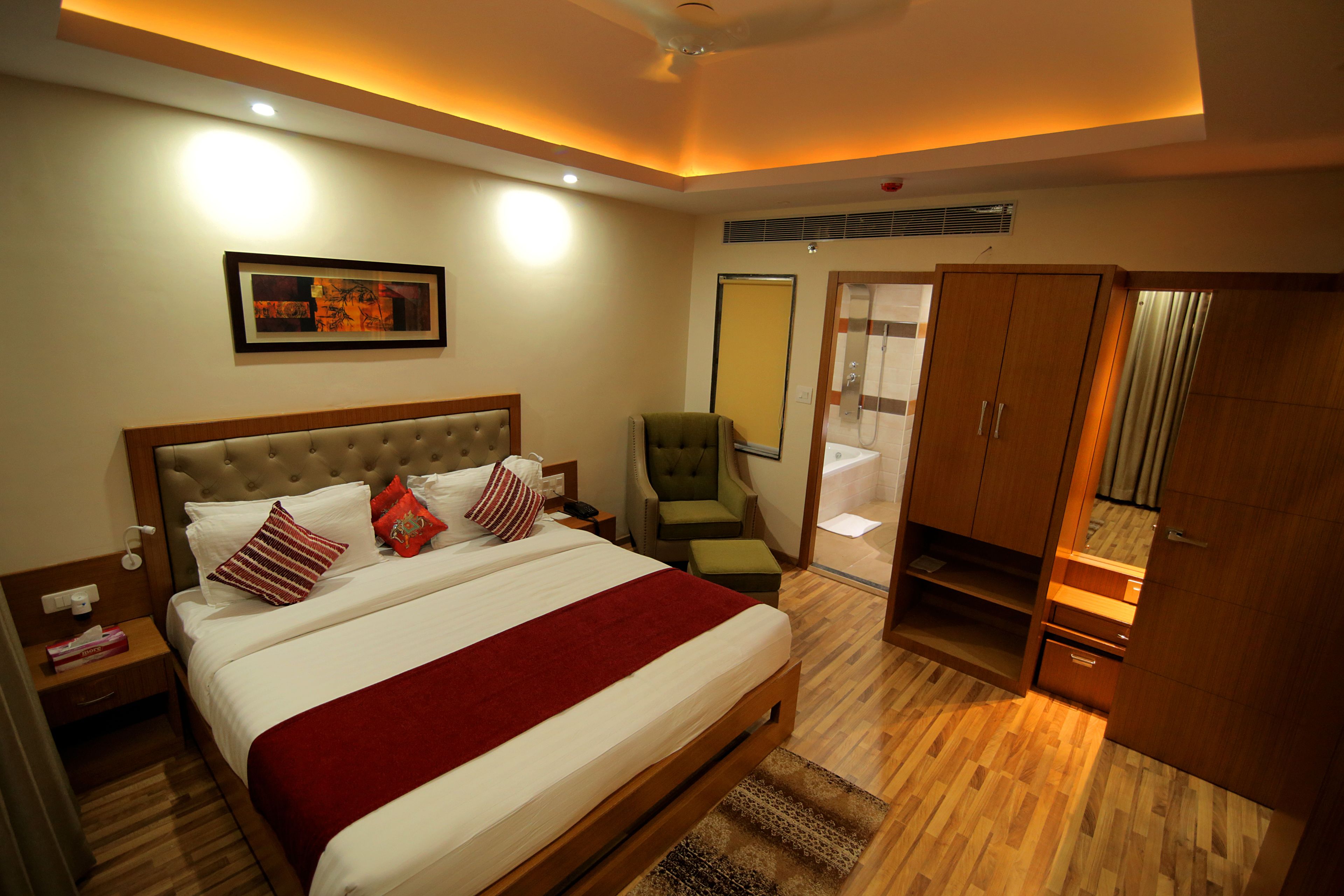 Une chambre d’hôtel avec un grand lit, une chaise, une armoire et un espace douche.