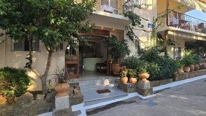 A two-story building with a balcony on the upper floor, a covered entrance, and potted plants. - Aphrodite Lemnos (Lemnos)