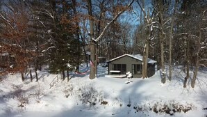 Une cabane entourée d’arbres couverts de neige.