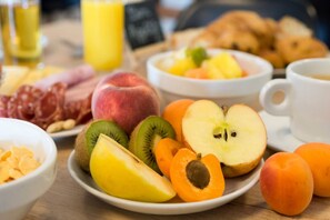 A breakfast table with various fruits, pastries, and a coffee cup. - The Originals City, Hôtel Le Puech (Narbonne)