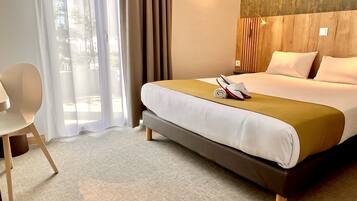 Una habitación de hotel con cama, una silla y vistas al exterior.