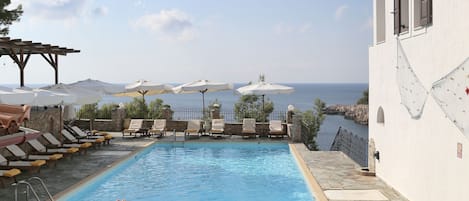 Piscine extérieure, parasols de plage, chaises longues