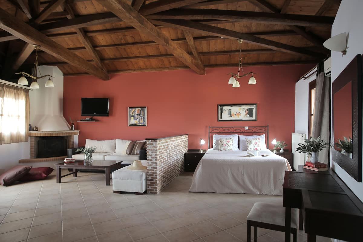 A cozy room with a fireplace, a bed, a sofa, and a dining table.