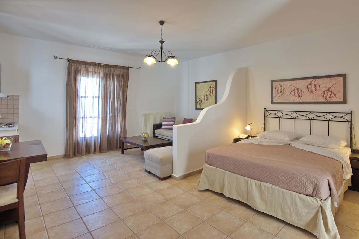 A bedroom with a bed, bedside tables, a desk, and a chair.