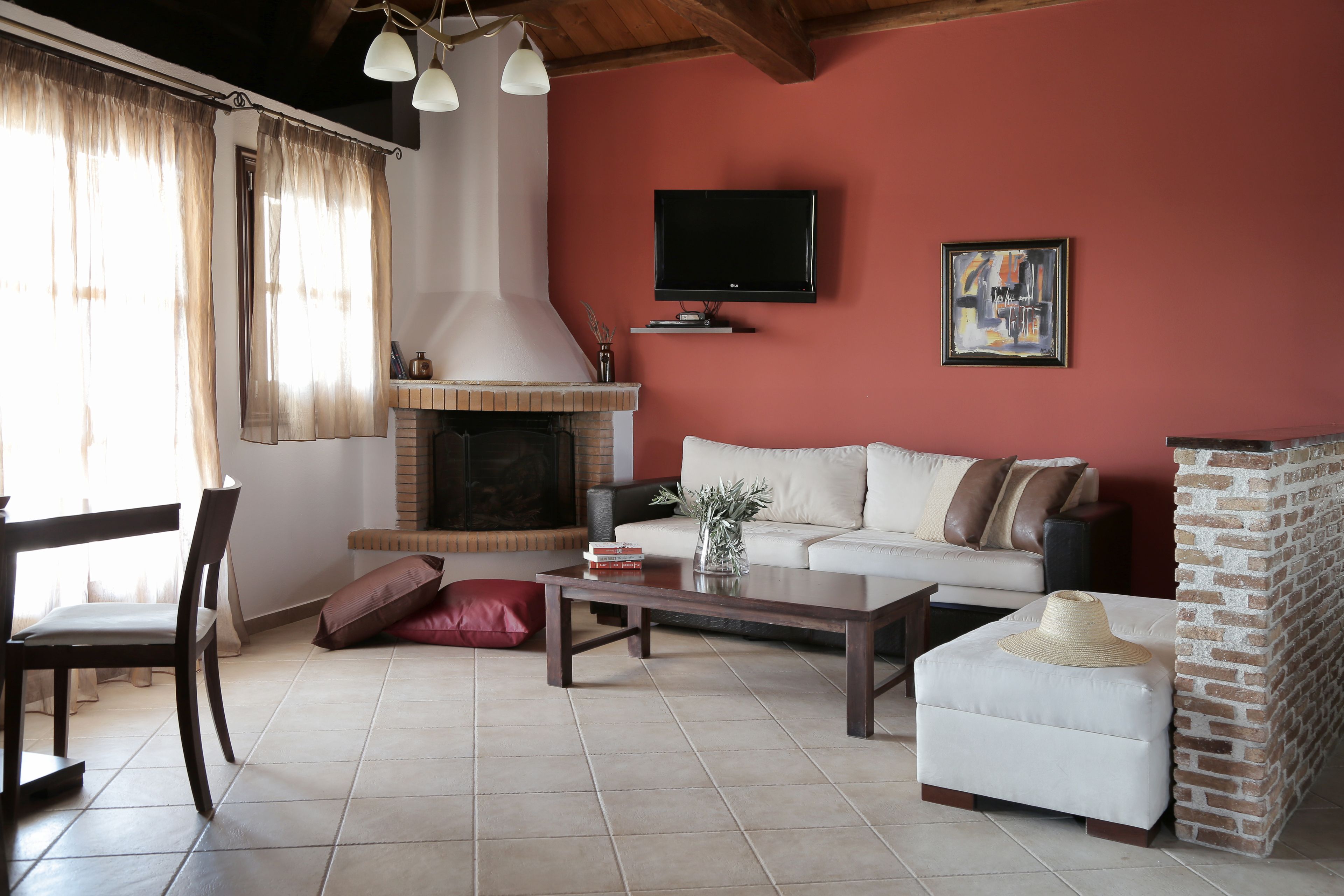 Una sala de estar con chimenea, un sofá, una mesa de centro y un televisor montado en la pared.