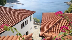 A coastal view with terracotta-tiled roofs and a clear blue sea. - Yalis Hotel (Alonissos)