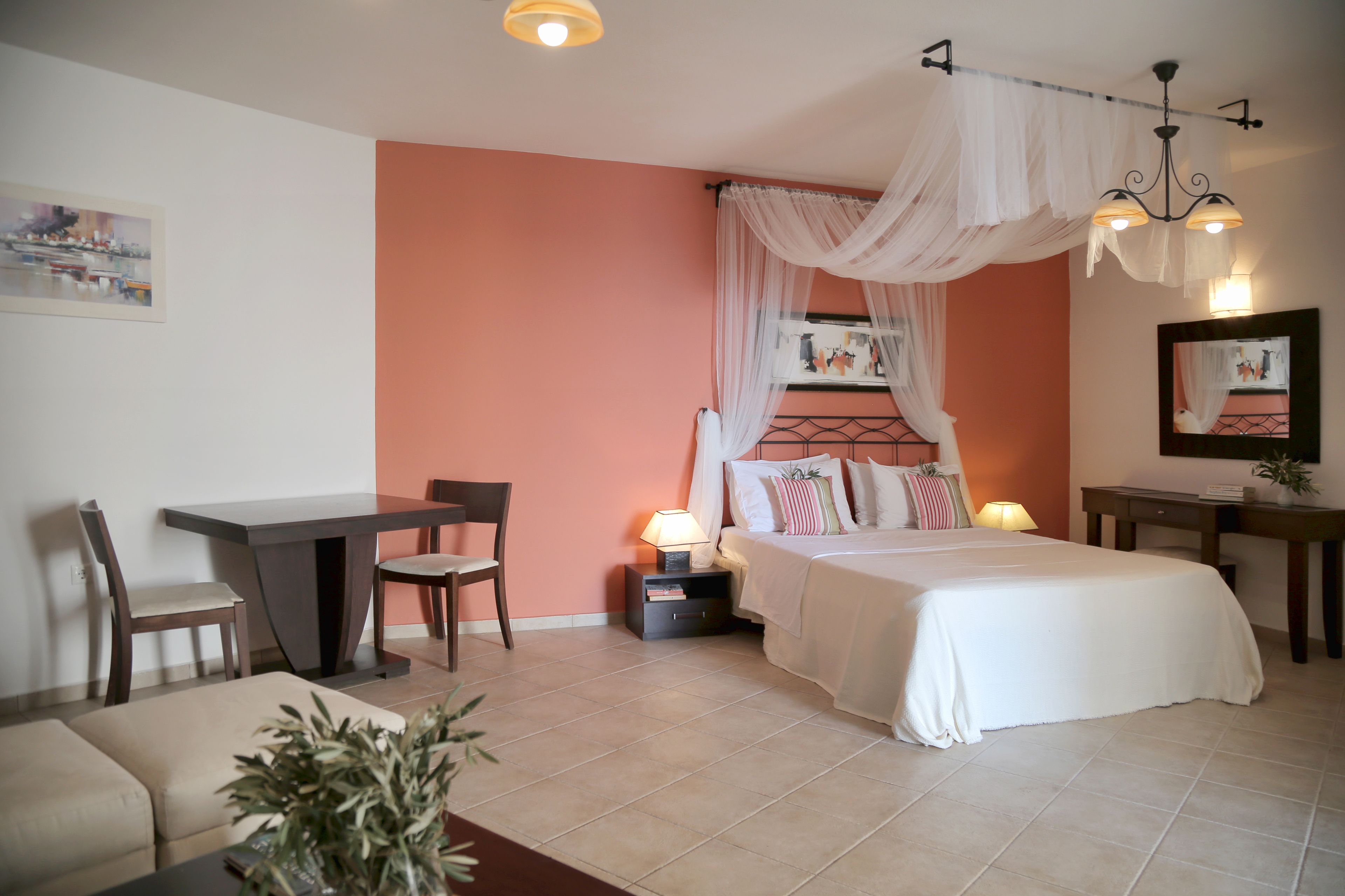 Une chambre à coucher comprenant un lit, une table de chevet, une lampe, une chaise et un bureau avec une autre chaise.