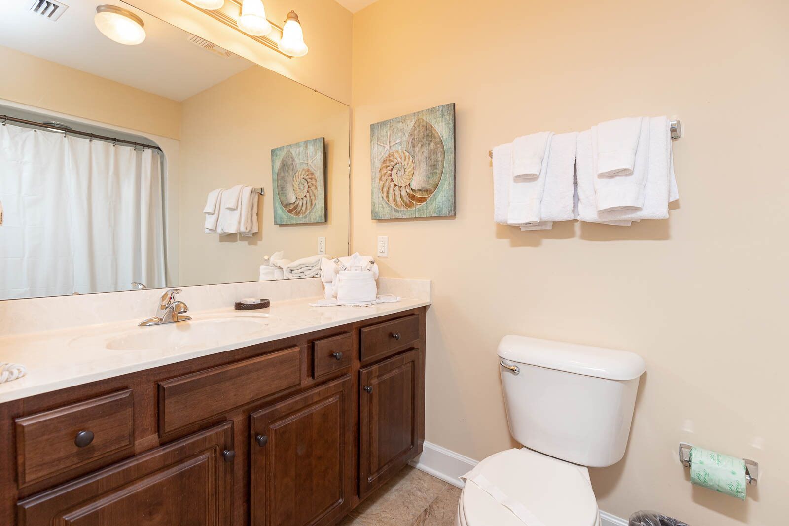 A bathroom with a sink, mirror, towel rack, and toilet.