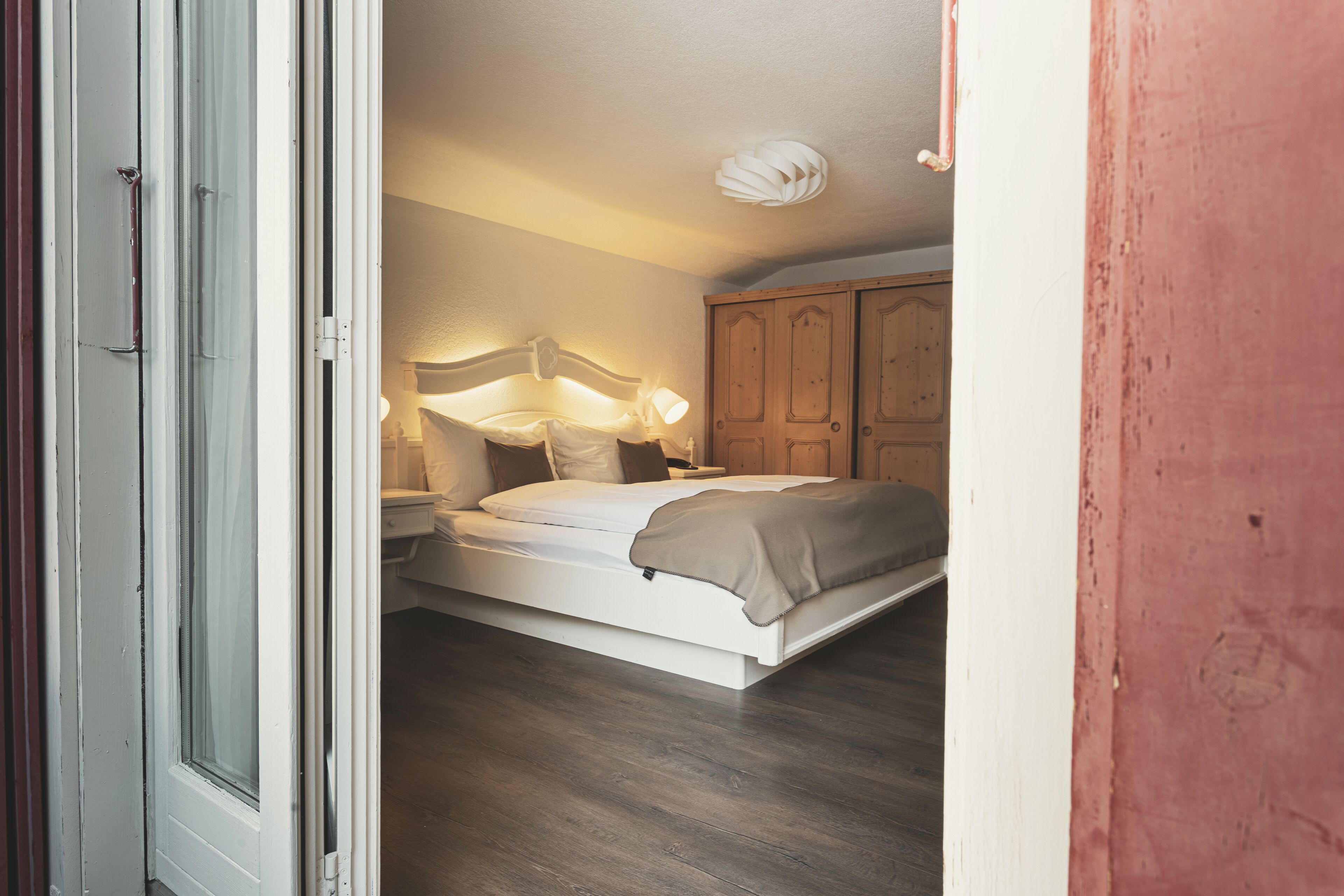 A bedroom with a bed, bedside tables, and a wardrobe.