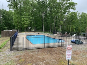A fenced outdoor swimming pool with a basketball hoop and lounge chairs. - Fall Special! 4+nights @ 15% off  | 9BR/9BA Private Dock + Hot Tub | Quiet Cove (LaFollette)