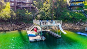 A dock with a small platform and a slide leading into a body of water.