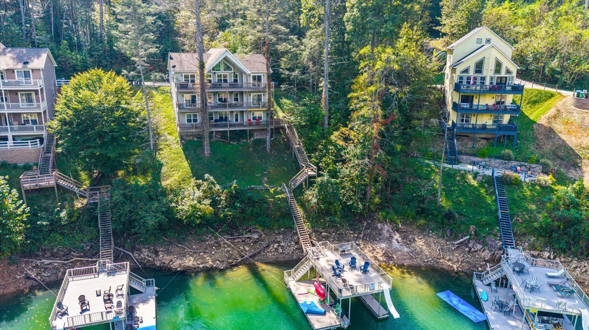 Un hotel de varios pisos con balcones, unidos por un puente de madera sobre un río.