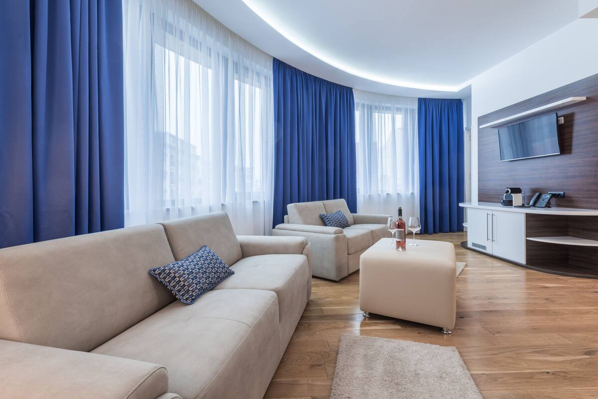 A modern living room with a beige sofa, a coffee table, and a TV mounted on the wall.