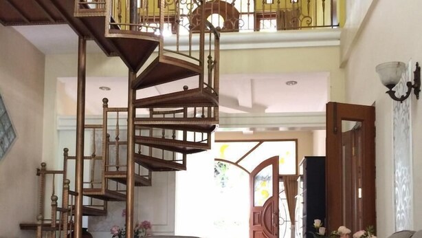 Un salon spacieux avec un escalier moderne, un canapé confortable et une table basse.