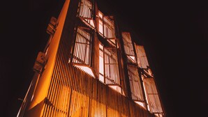 A building with a sloped roof and vertical wooden panels. - Floral Holiday Guesthouse (Dali)
