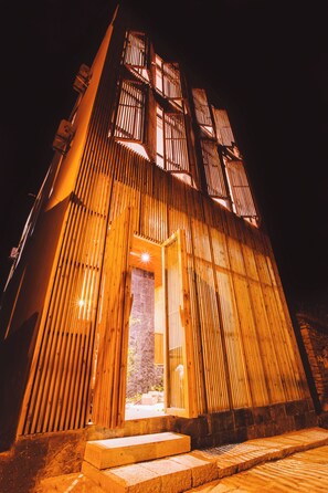 Un edificio con techo inclinado y paneles de madera verticales.
