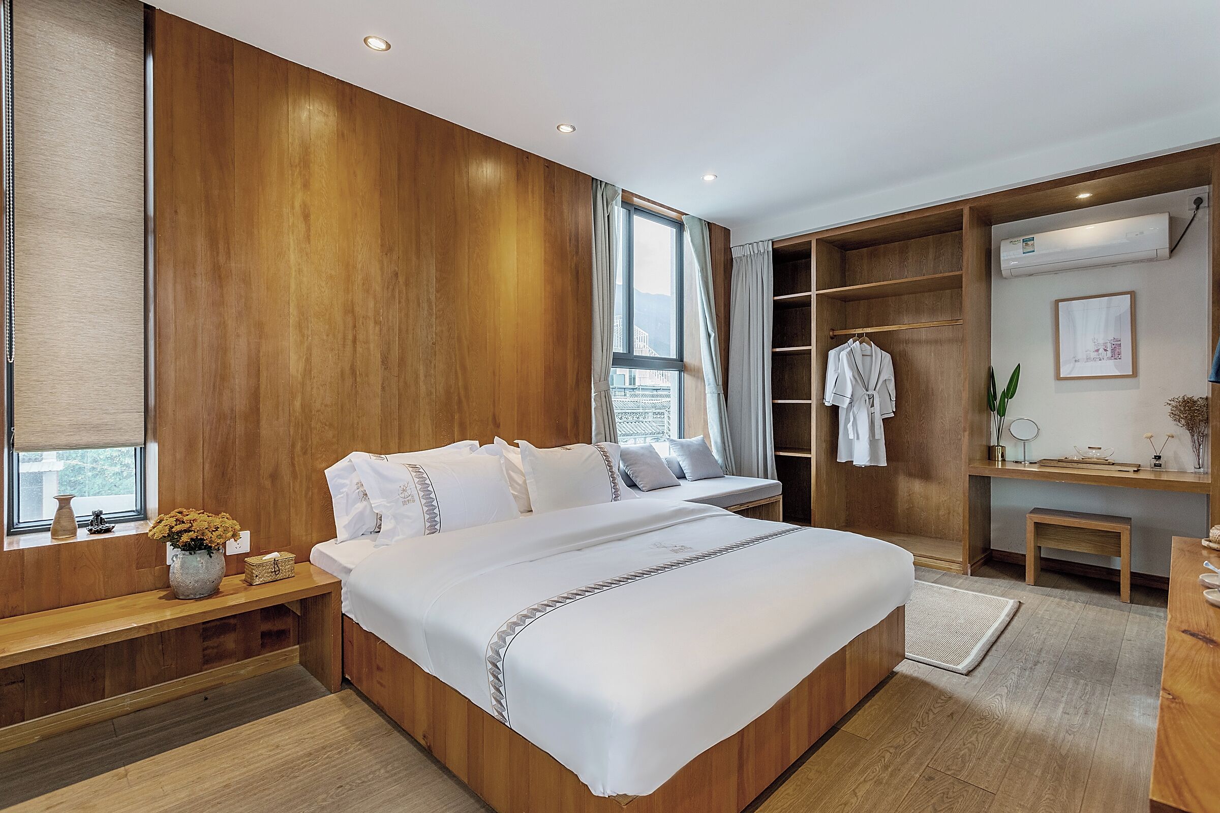 Une chambre à coucher moderne avec un lit en bois, une armoire intégrée et une table de chevet agrémentée d’un vase de fleurs.
