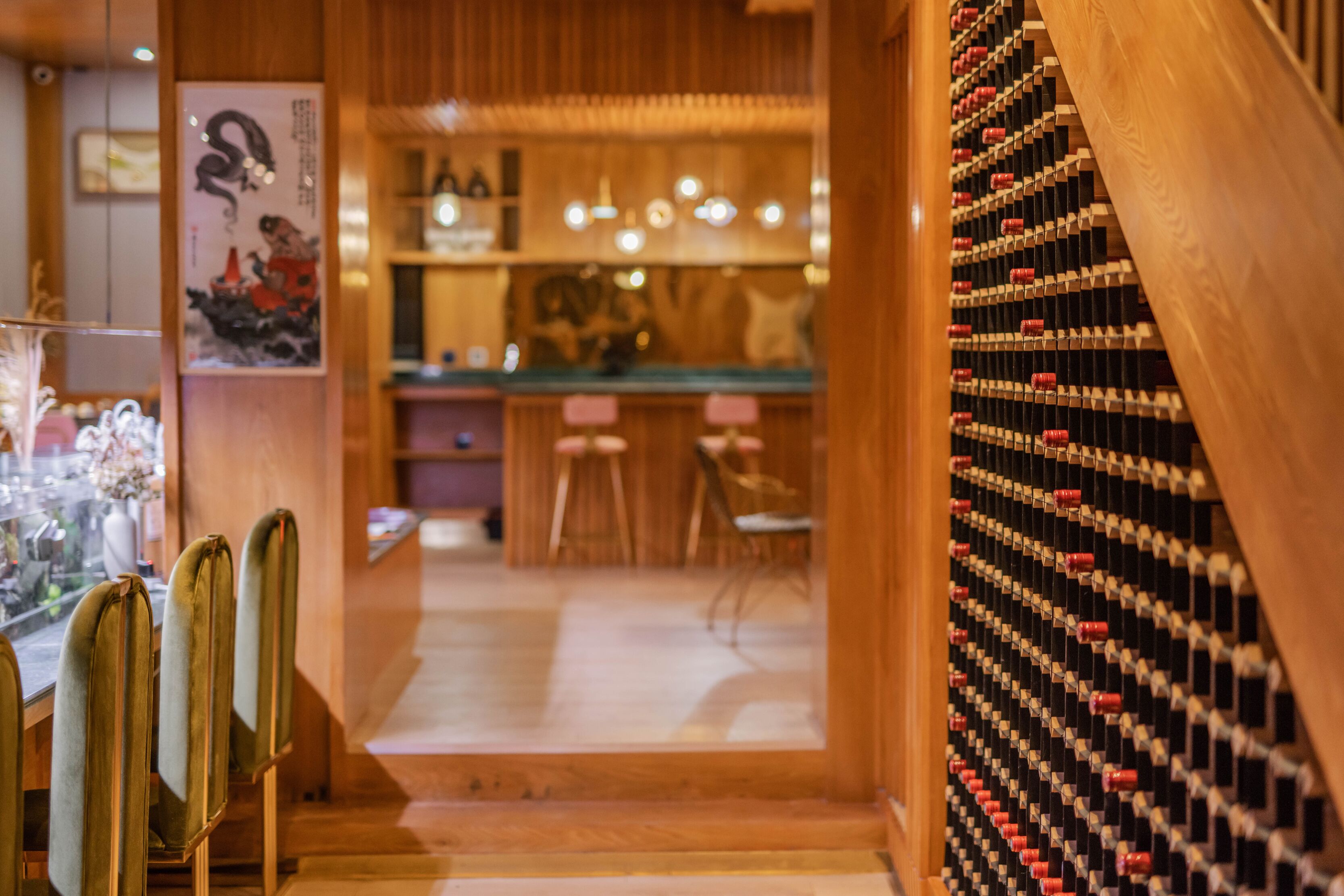 Un restaurante con decoración de madera, una barra de sushi y una estantería para vinos.