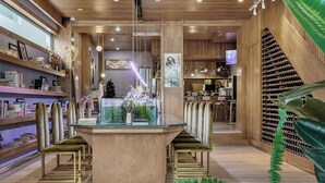 A modern interior with a central glass table, wooden shelves, and a wine rack. - Floral Holiday Guesthouse (Dali)