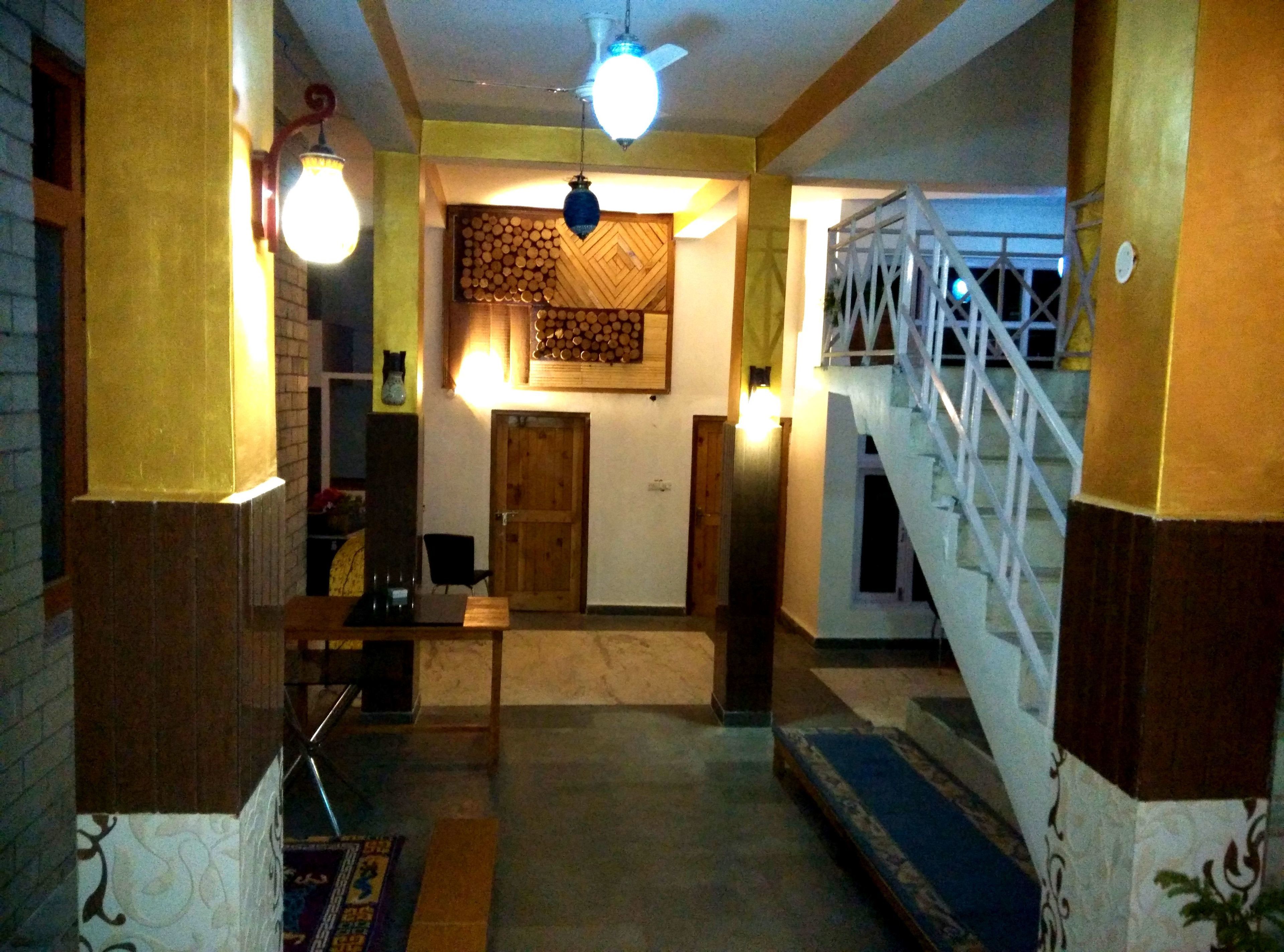 A hallway with a staircase, a wooden door, and a wall with a decorative pattern.