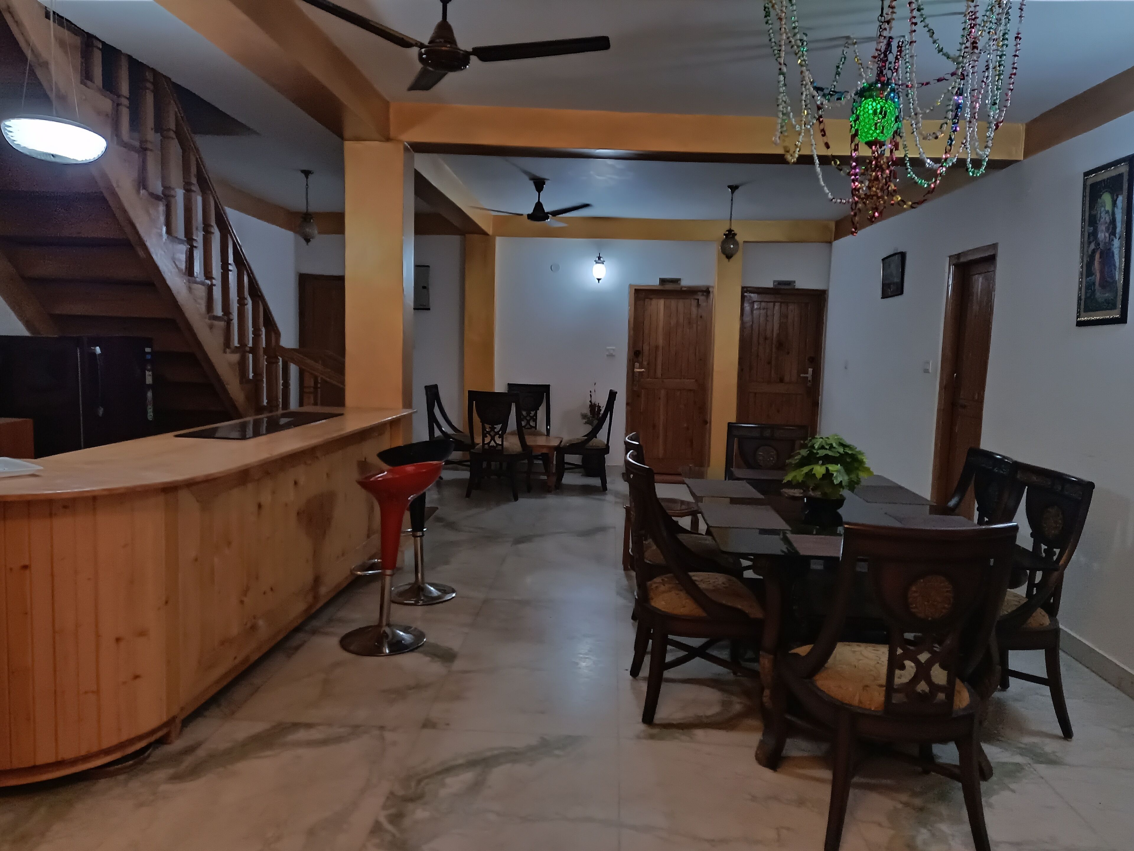 A spacious dining area with a wooden counter and multiple chairs.