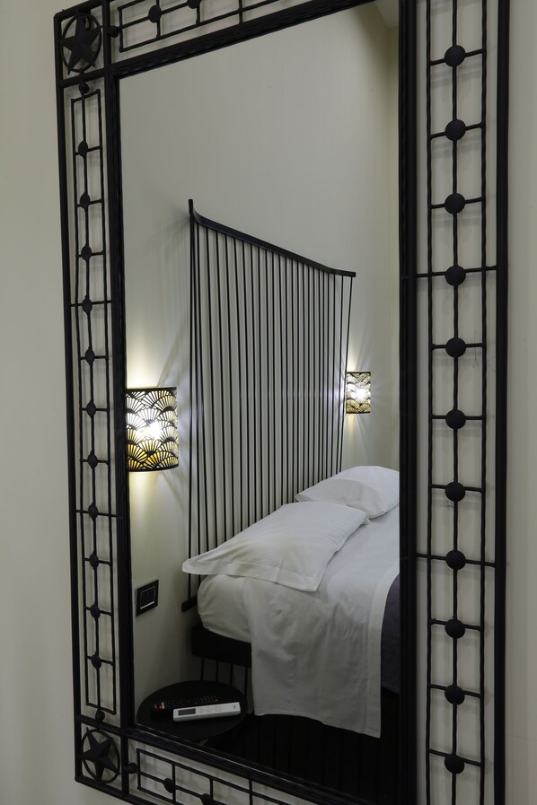 A bedroom with a bed, bedside table, and two wall-mounted lamps. - Il Salotto della Regina (Naples)