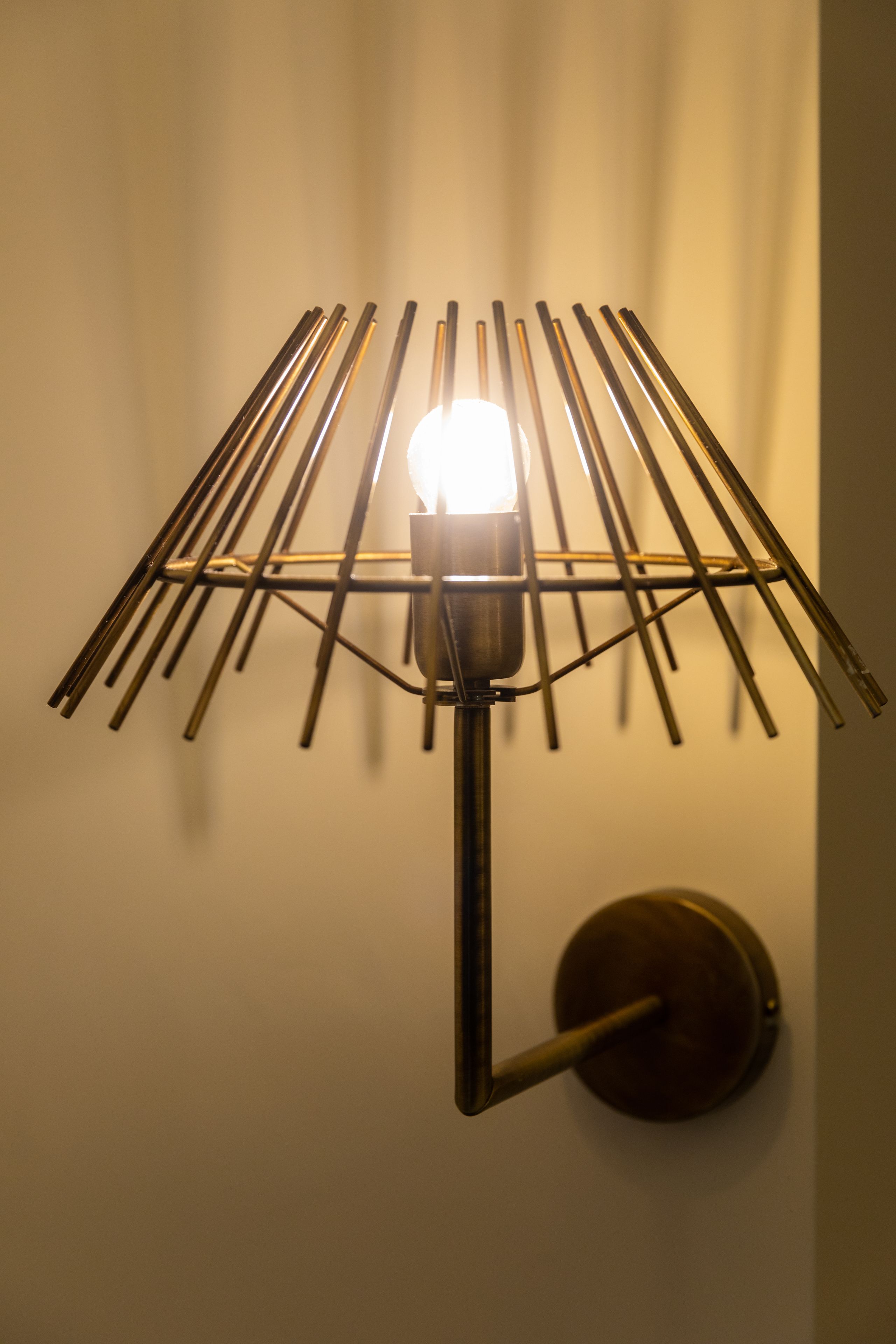 A wall-mounted lamp with a metal frame and a visible light bulb.