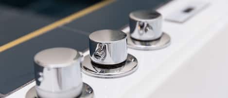 A close-up of three chrome knobs on a white surface.