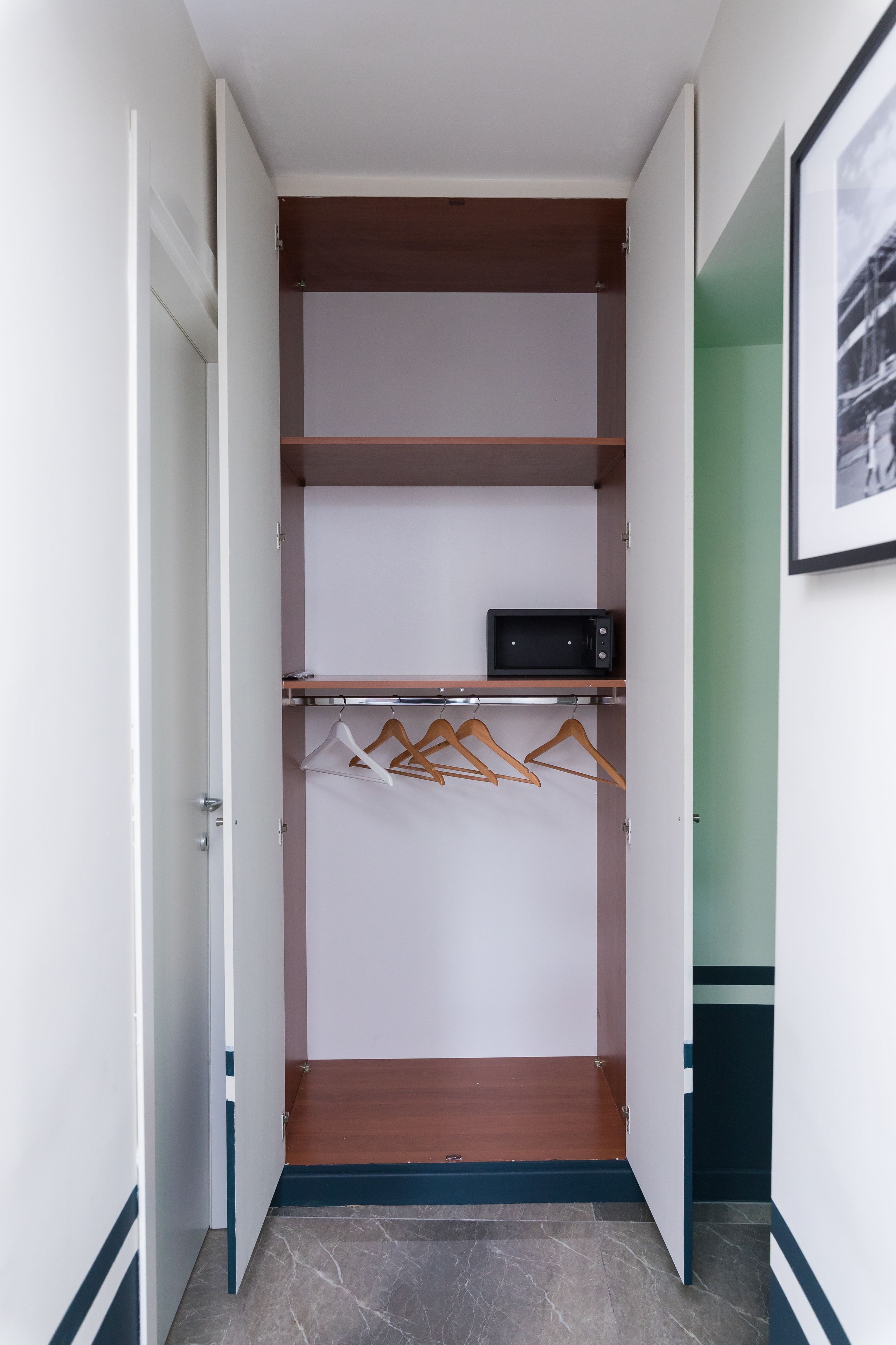 Un closet amplio con estantes de madera, un microondas y ropa colgada.