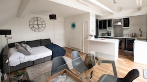 Un appartamento moderno con zona living, tavolo da pranzo e cucina.