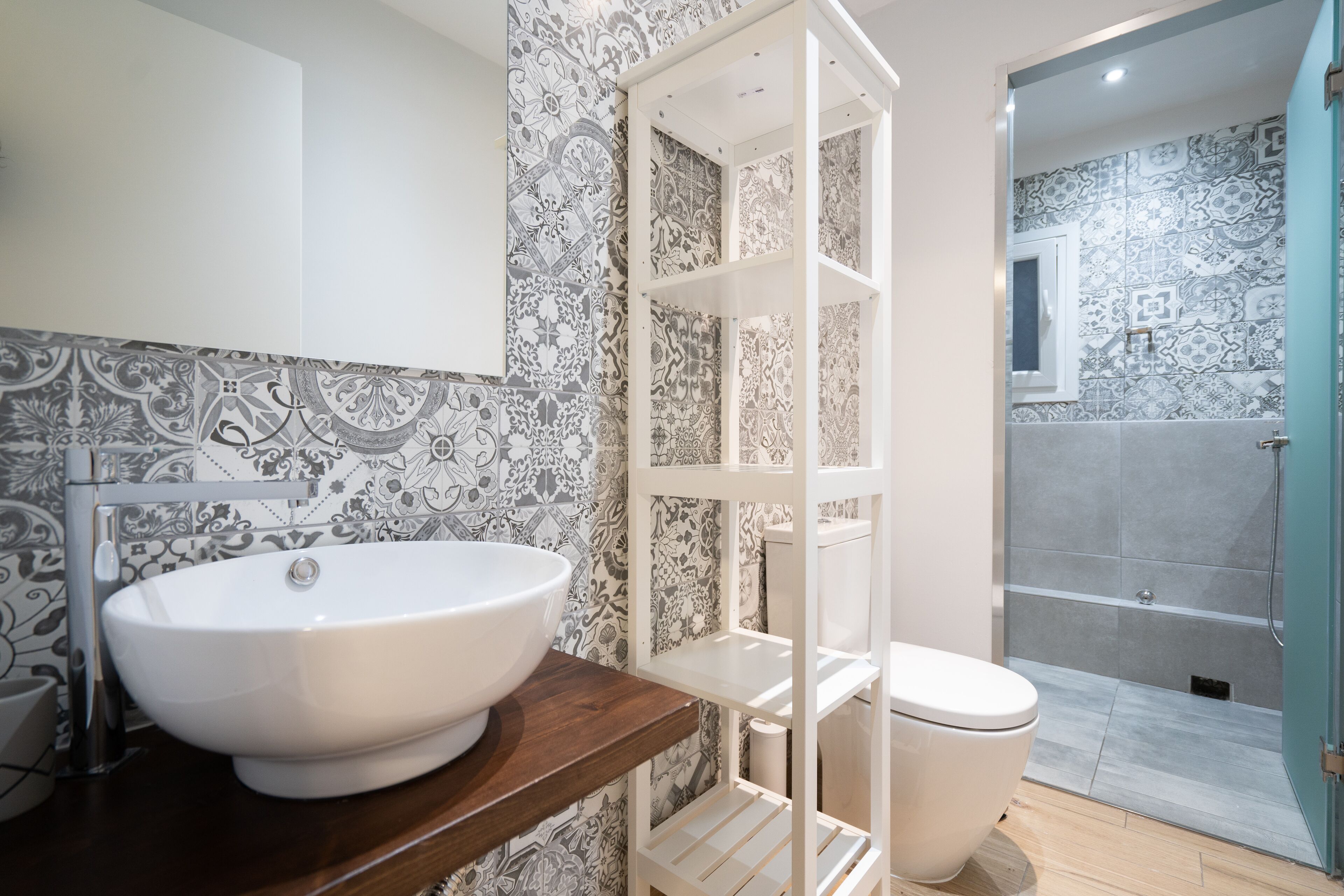 Une salle de bain avec un lavabo blanc, des toilettes et un espace douche.