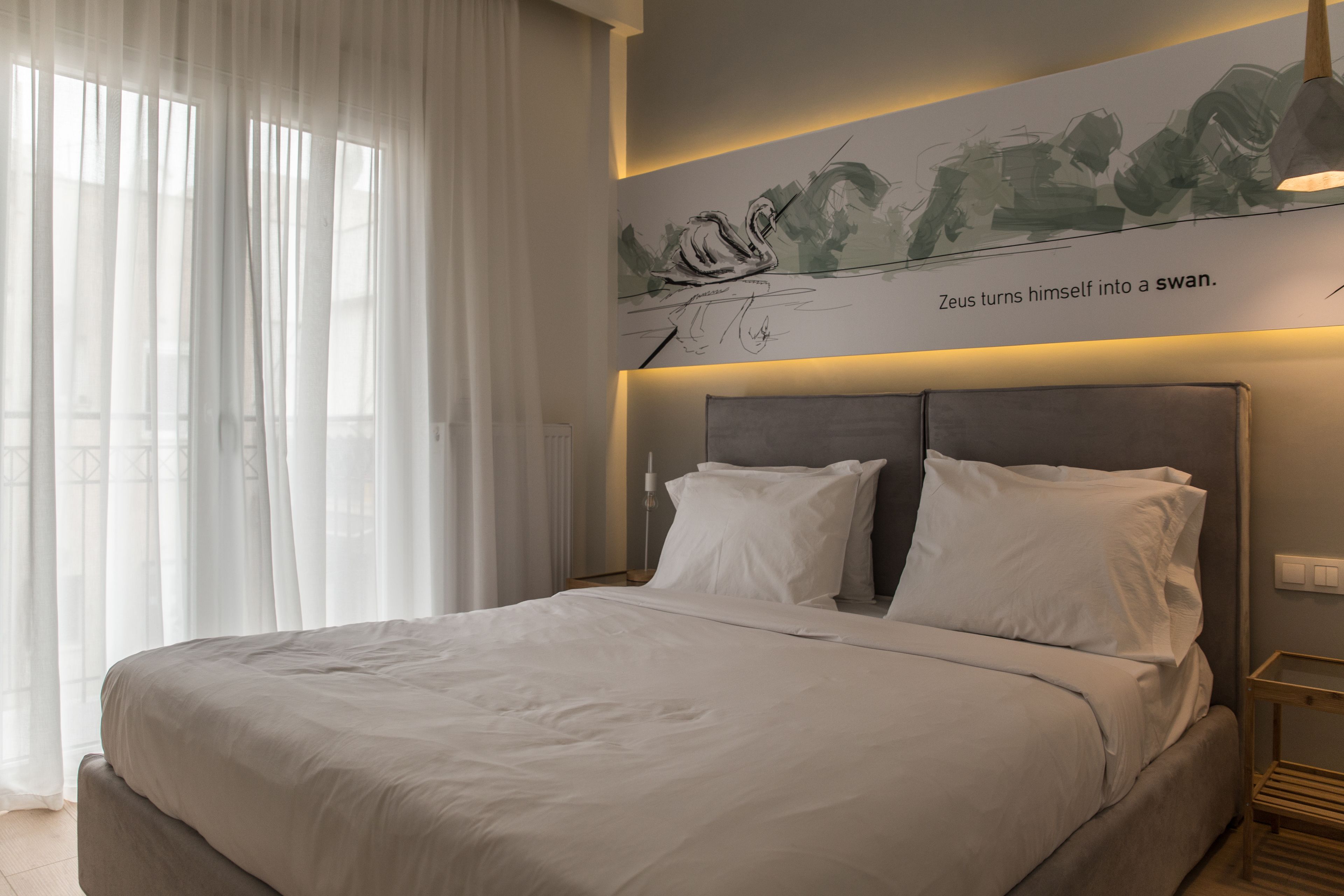A modern bedroom with a large bed, white bedding, and a wall art depicting a swan.