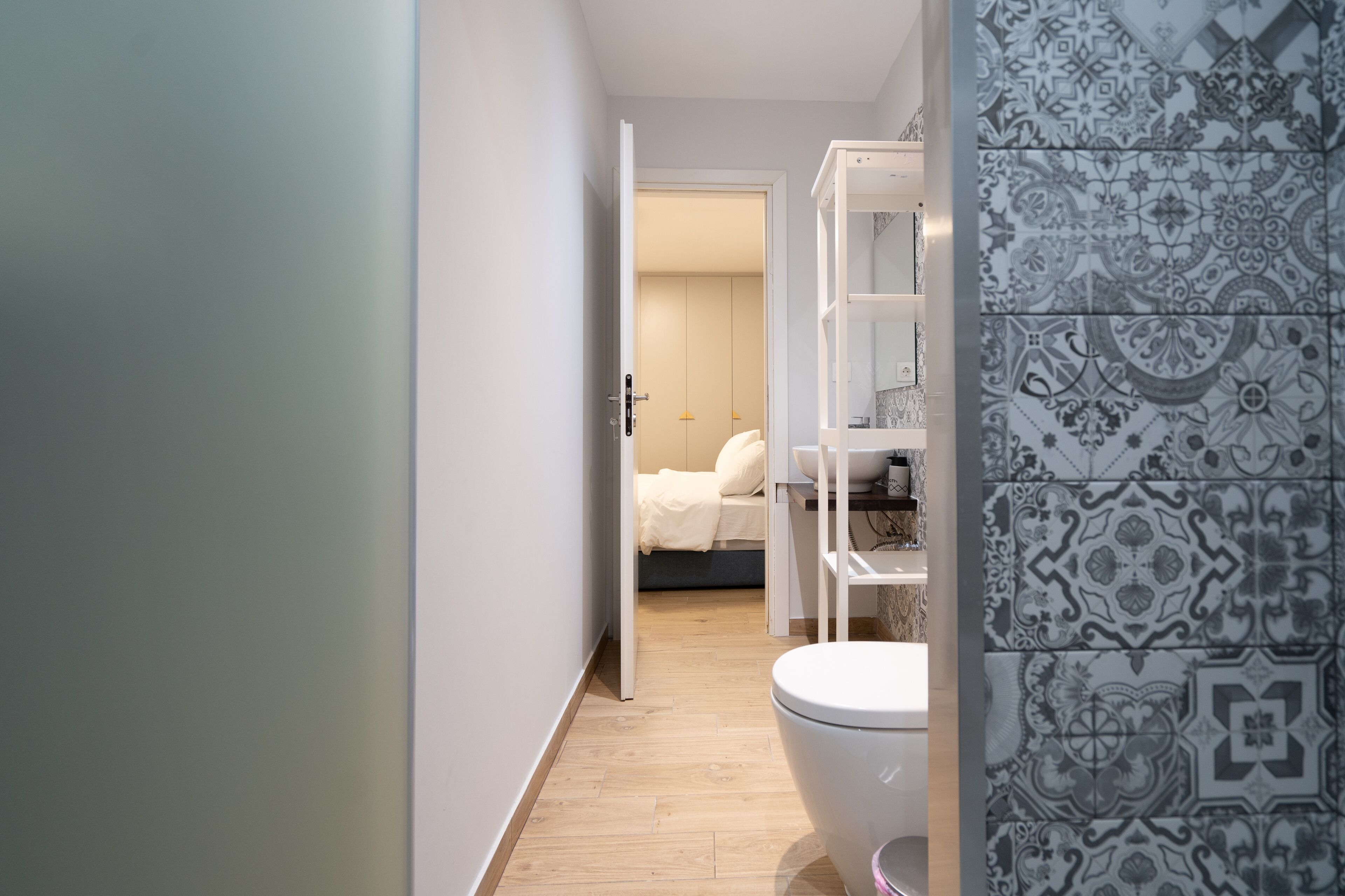 A modern bathroom with a toilet, a shower area, and a storage cabinet.