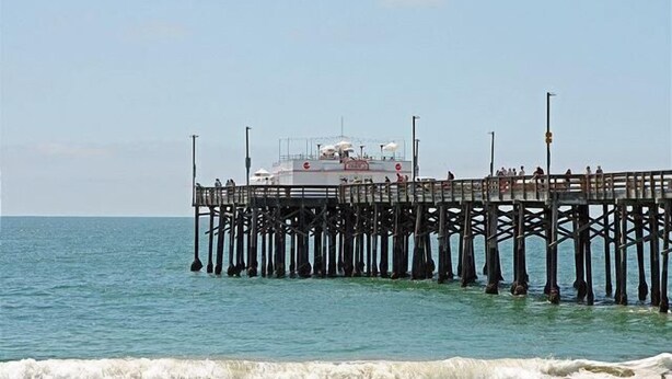 Un muelle que se adentra en el mar, con un edificio al final.