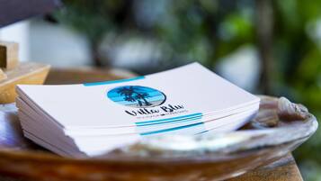 A stack of business cards with a palm tree logo and the text "Villa Blu" on a wooden surface.