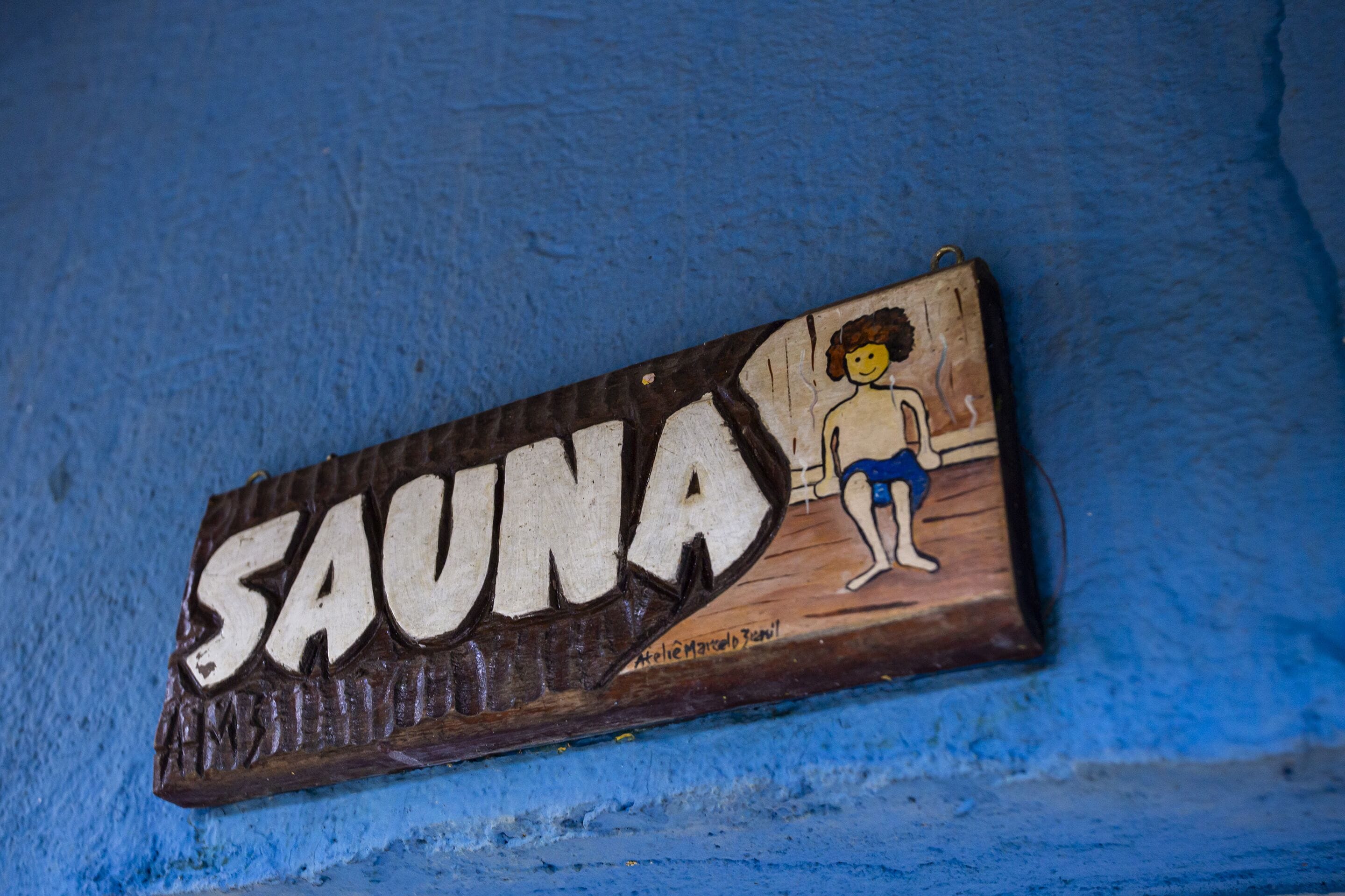 A wooden sign with the word "SAUNA" and a drawing of a person.