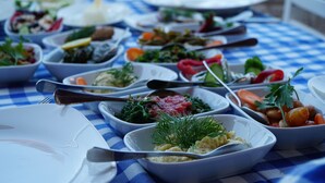 A table with various dishes and utensils, suggesting a dining setting. - Trilyali Butik Otel (Mudanya)