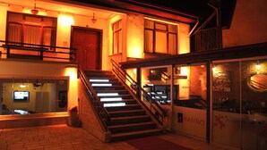 A hotel entrance with a staircase leading to the upper floor, a reception desk, and a visible sign for the hotel. - Hasirci Konaklari (Amasya)