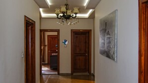 A hallway with a ceiling light fixture, a radiator, and a door leading to another room. - Hasirci Konaklari (Amasya)