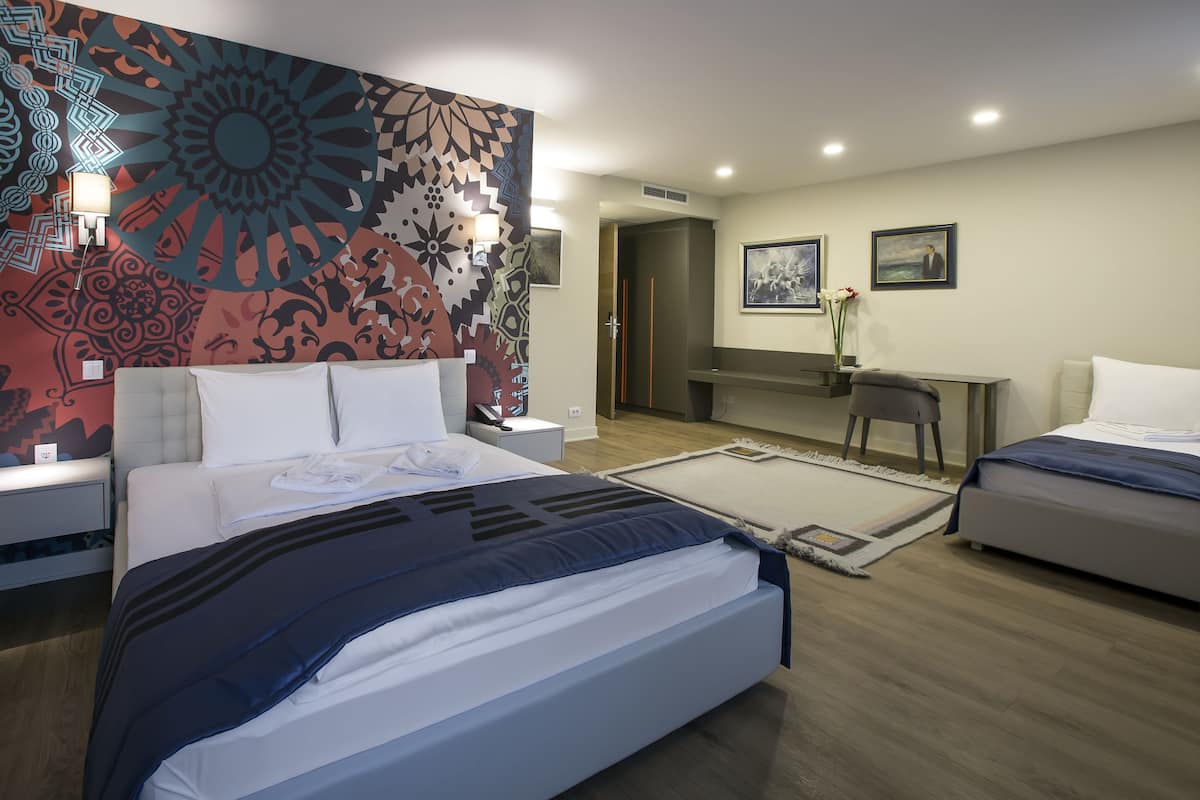 Une chambre d’hôtel moderne avec un grand lit, un bureau et un miroir.