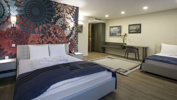Una habitación de hotel moderna con una cama grande, un escritorio y un espejo.