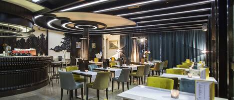 Un restaurante con una decoración moderna, que incluye una zona de bar, varias mesas y sillas.