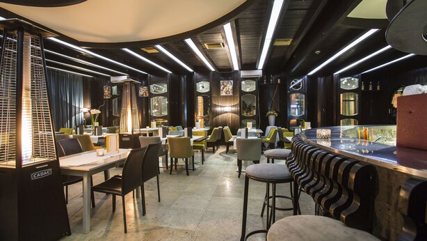 A modern restaurant interior with high ceilings, linear lighting, and a mix of seating arrangements. - Zepter Hotel Drina Bajina Bašta, member of Zepter Hotels (Bajina Bašta)