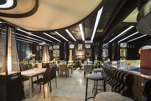 A modern restaurant interior with high ceilings, linear lighting, and a mix of seating arrangements. - Zepter Hotel Drina Bajina Bašta, member of Zepter Hotels (Bajina Bašta)