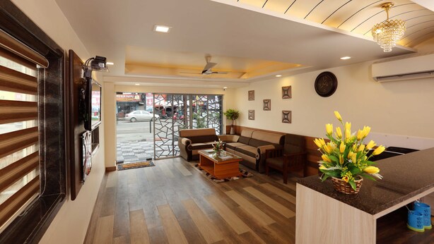 Eine Hotellobby mit Holzboden, einer Couch, einem Couchtisch und einer dekorativen Vase mit Blumen.