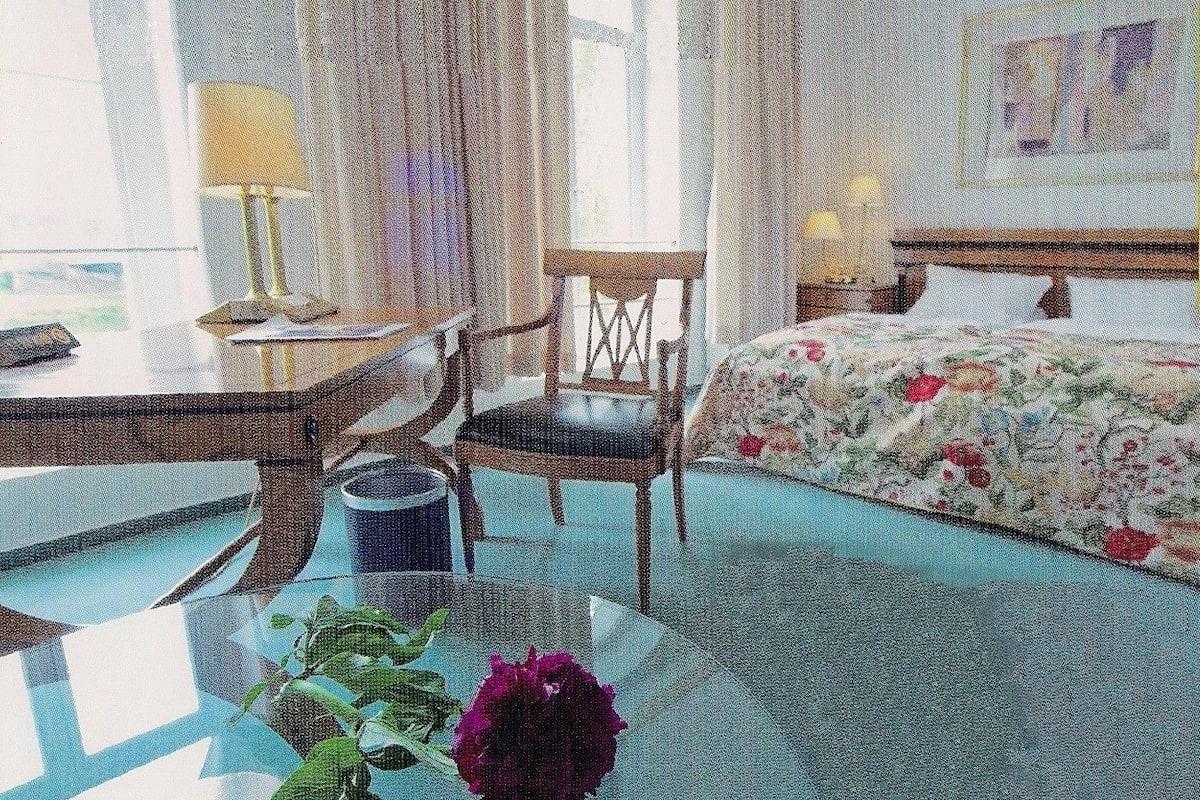 A room with a bed, a desk, a chair, and a window.