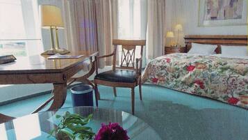 A room with a bed, a desk, a chair, and a window.