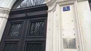 A building entrance with a dark wooden door, a white archway, and a sign reading "5 VIA GIULIA". - House5 (Trieste)