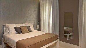 A modern bedroom with a bed, curtains, and a mirror. - House5 (Trieste)